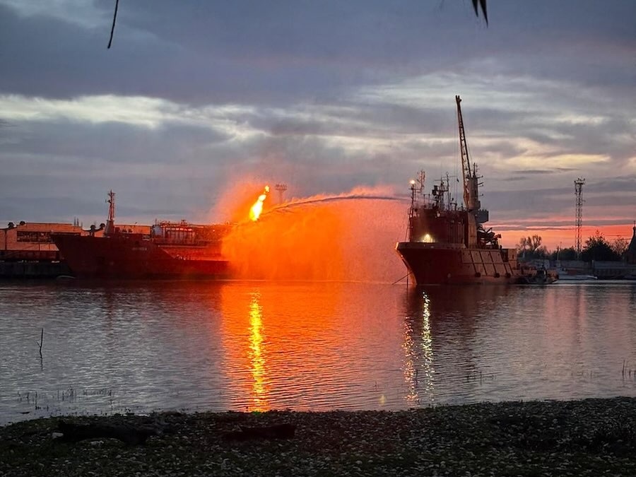 Украинское судно поливает водой грузовое судно, загруженное сжиженным нефтяным газом, охваченное пламенем после российских ударов по Измаилу в ноябре. 