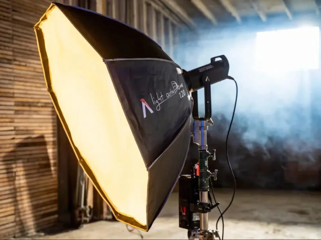 Моноблок Aputure LS 300x із надітим софтбоксом Light OctaDome 120 випромінює м'яке тепле світло в задимленому приміщенні студії
